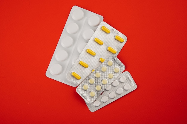 Pills on red background. healthcare concept. top view.