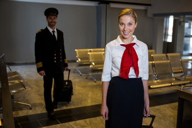 Pilot and air hostess walking with their trolley bags