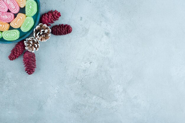 Pine cone arrangement and a platter of marmelades on marble.