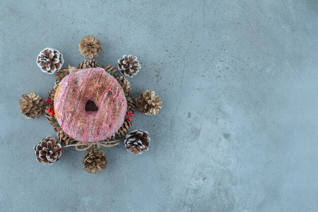 대리석 표면에 화환에 도넛 주위에 소나무 콘