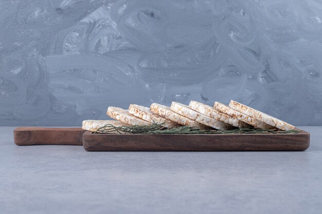 Pine leaves adorning a tray of cookies on marble