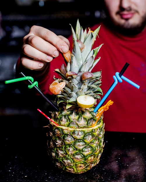 Pineapple cocktail served in pineapple with tangerine and pear slices 1