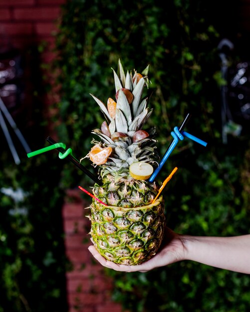 Pineapple cocktail served in pineapple with tangerine and pear slices 2