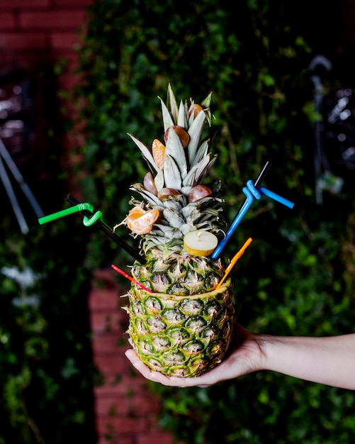 Pineapple cocktail served in pineapple with tangerine and pear slices 2