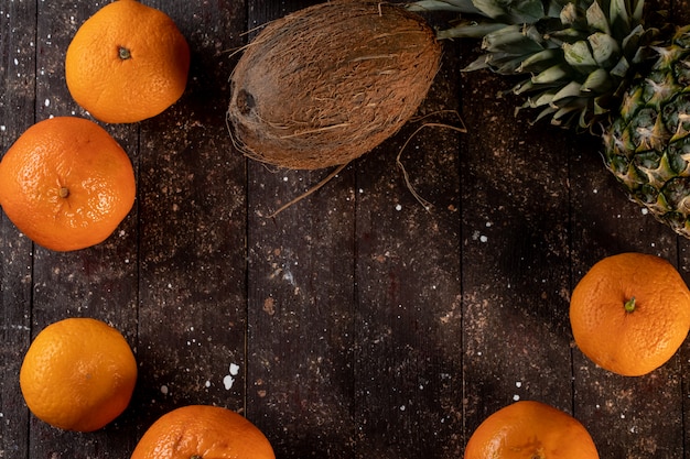 Pineapple coconut and mandarin on a wooden table