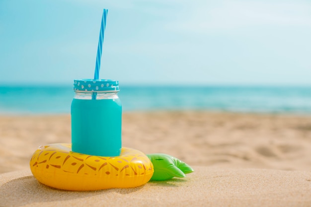 Pineapple juice with an inflatable at the beach