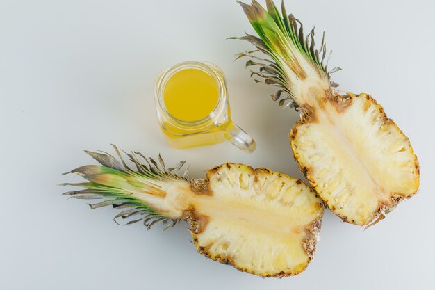 Pineapple slices with juice on white surface