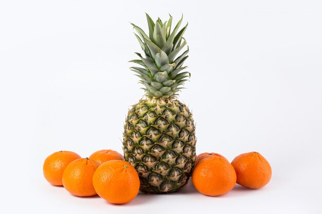 Pineapple tangerines fresh ripe mellow juicy whole tasty fruits on a white