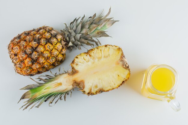 Pineapple with juice on a white surface