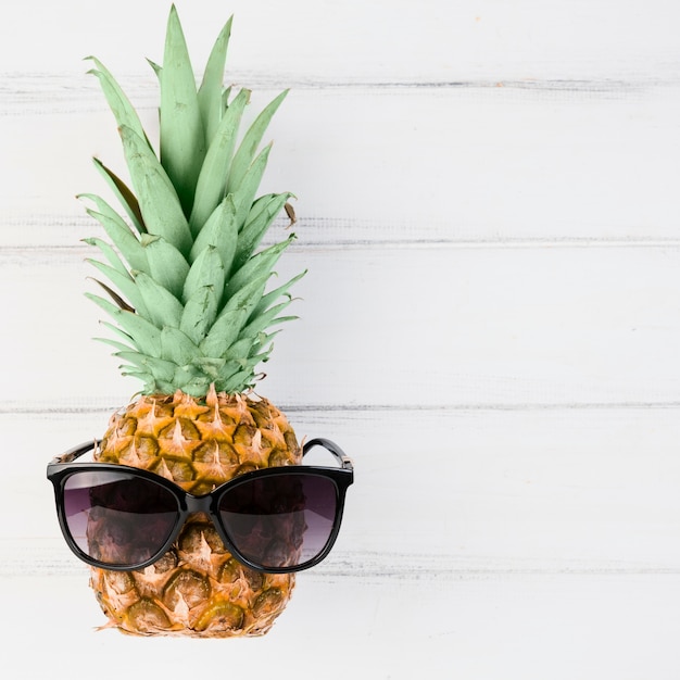Foto gratuita ananas con occhiali da sole a bordo