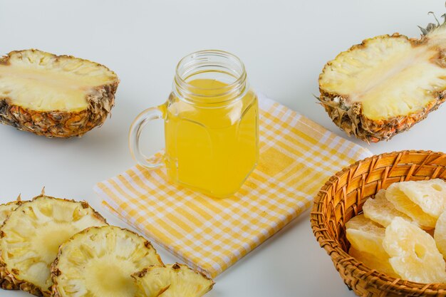 Pineapples with juice and candied rings on checkered kitchen towel