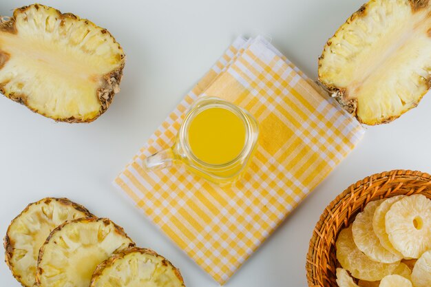 Pineapples with juice and candied rings on checkered kitchen towel