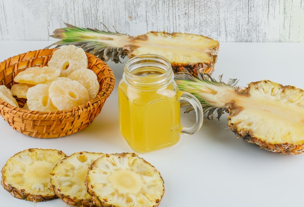 Pineapples with juice and candied rings on wicker basket