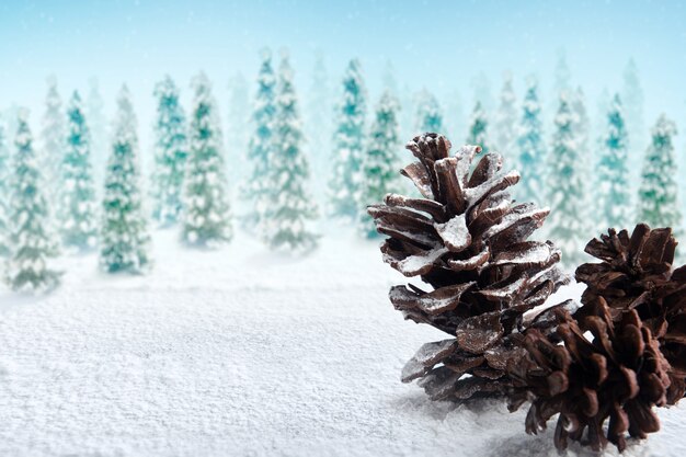 Pinecone on the snow with snowy fir trees background. Christmas decoration