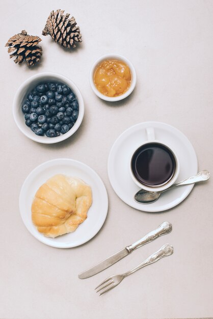 Pinecones; blueberries; jam; bread and coffee cup on white background