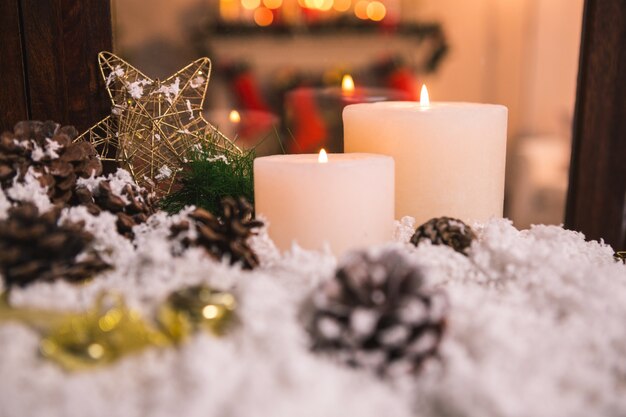 Pinecones on fake snow and canddles