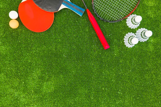 Ping-pong balls; shuttlecocks; badminton and rackets on green turf