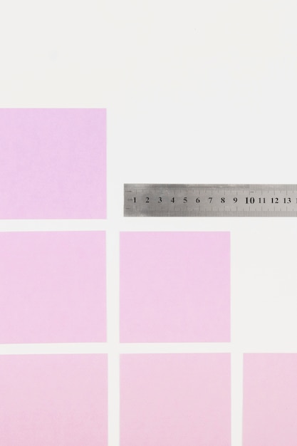 Pink adhesive notes and ruler on white background