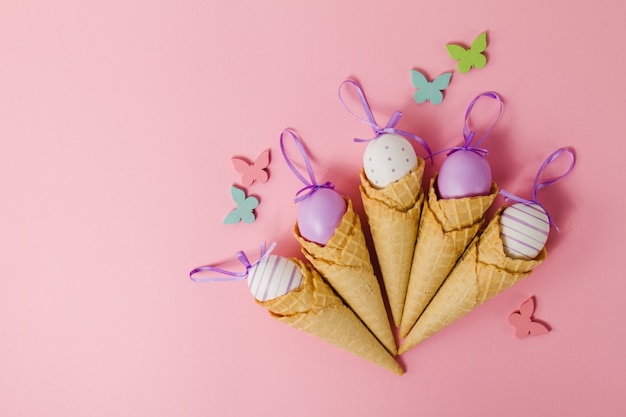 Foto gratuita sfondo rosa con coni e le uova di pasqua