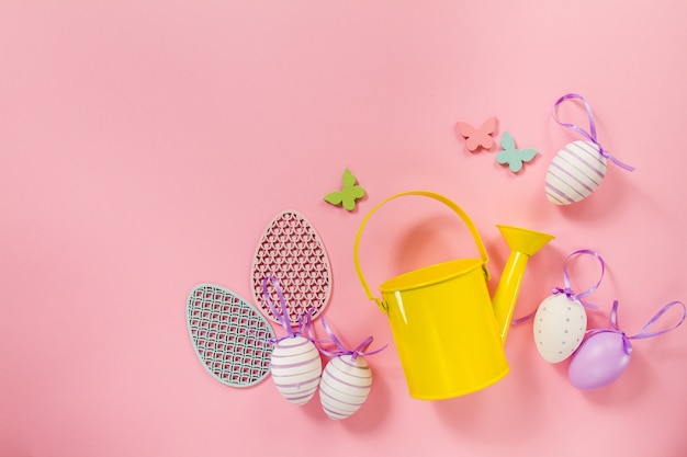 Pink background with easter eggs and yellow watering can