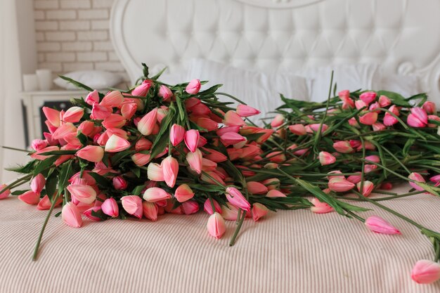 Pink beautiful wedding tulips on classic bed, close up