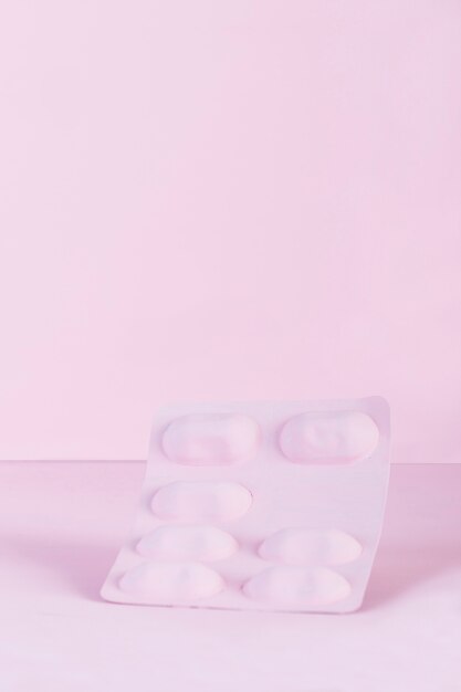 Pink blister pills pack on pink backdrop