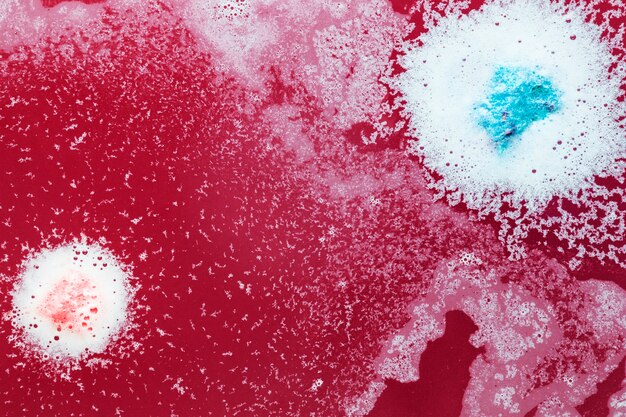 Free photo pink and blue drops on red water
