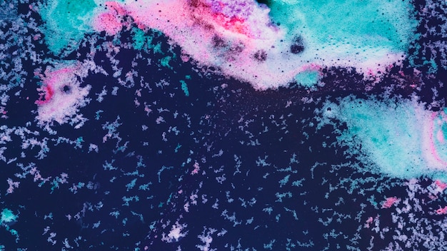 Pink and blue foam on water