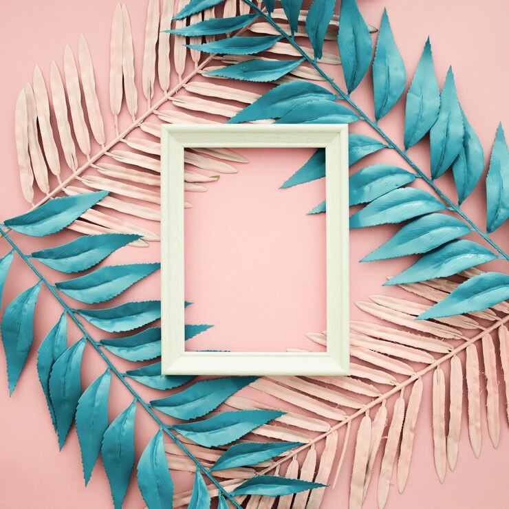 Free Photo pink and blue leaves on pink background with blank frame