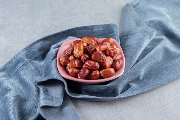 Pink bowl of tasty ripe silverberries on marble background.