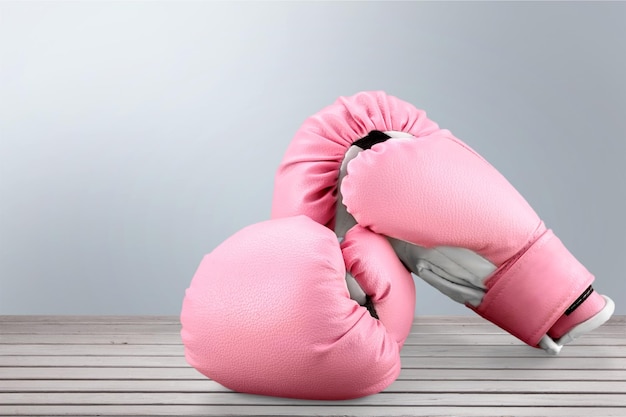 Pink boxing gloves on wooden background