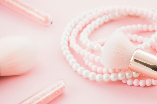 Pink brushes and pearl necklace