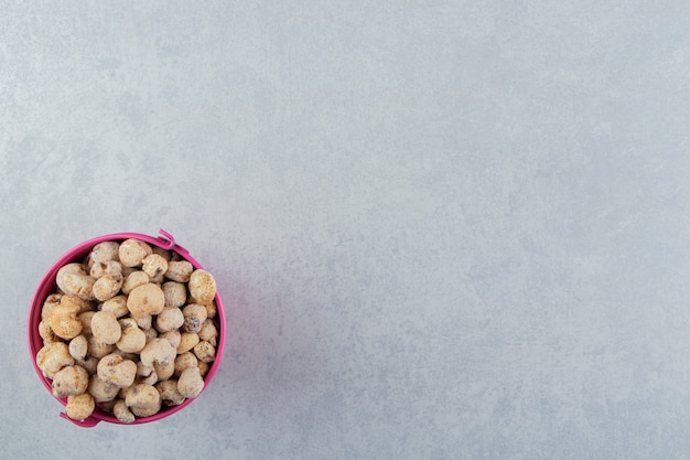 A pink bucket full of delicious dried fruit .