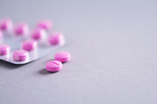 ピンク​の​カプセル​、​錠剤​、​灰色​の​背景上​の​ビタミン​。​コピー​スペース​。​たくさん​の​薬​、​風邪​の​治療​。​女性​の​病気​の​治療​。​バナー