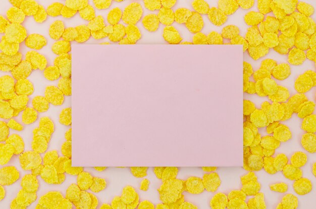 Розовая открытка в окружении кукурузных хлопьев