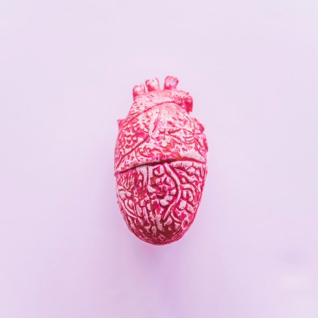 Pink ceramic human heart on table 