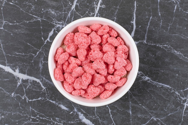 Pink cereal flakes on white plate.