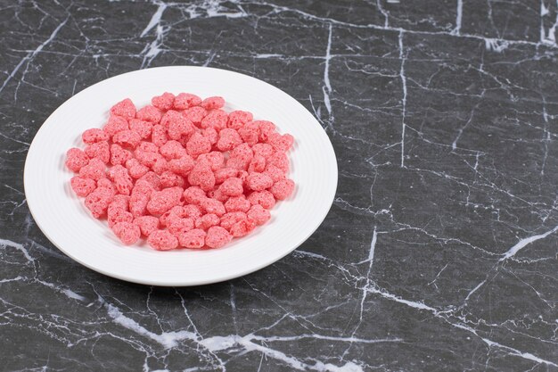 Pink cereal flakes on white plate.