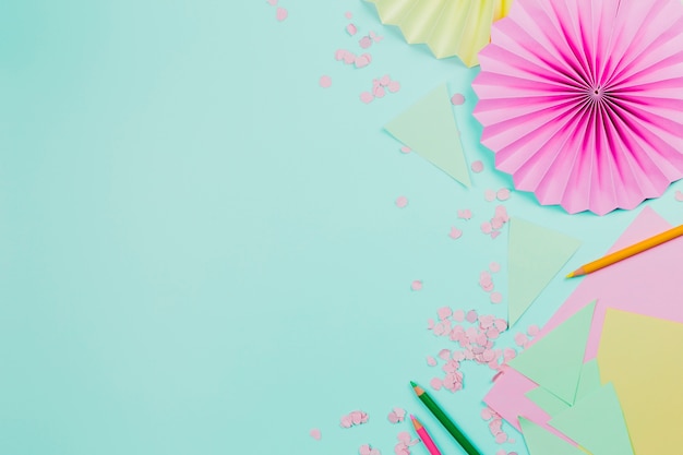 Pink circular paper fan made with paper on mint green backdrop