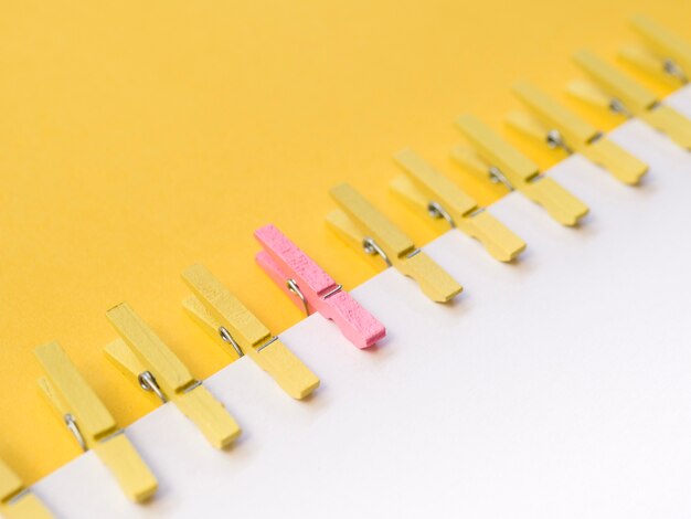 Pink clothespin in center of yellow clothespins