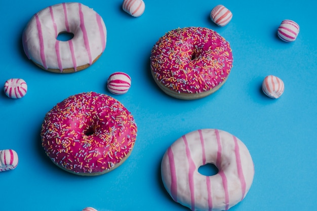 Бесплатное фото Розовые цветные конфеты на синем фоне