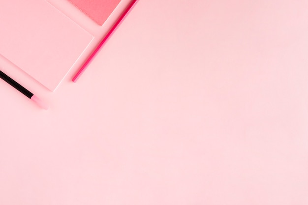 Розовая композиция с канцелярскими товарами на цветном фоне