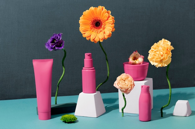 Free photo pink cosmetic containers and flowers arrangement