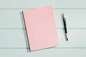 Free photo pink cover of a notepad with pen