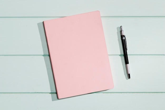 Pink cover of a notepad with pen