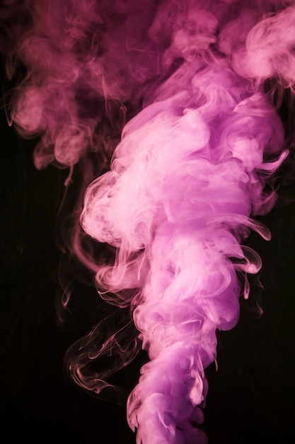 黒の背景にピンクの創造的な煙