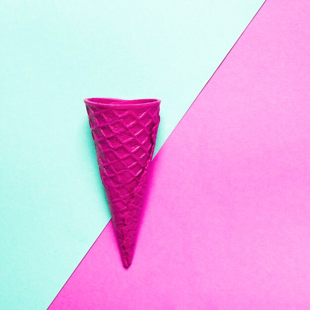 Pink crispy ice cream cone on colorful background