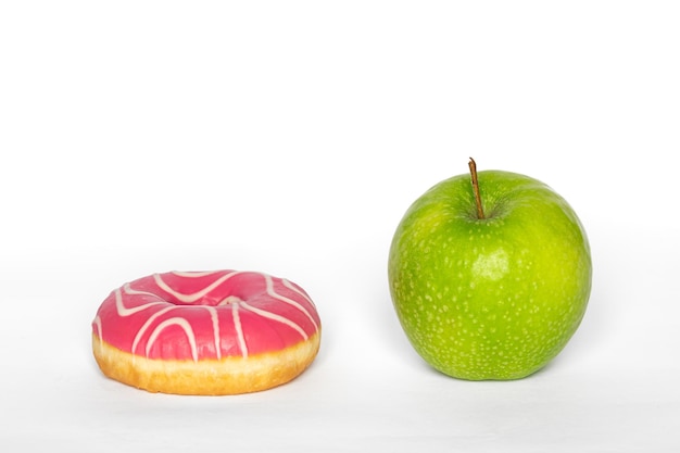 Free photo pink donut and apple healthy food and diet concept