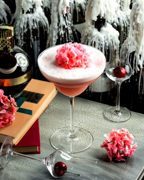 ガラスの泡とピンクの花でピンクの飲み物