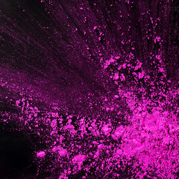 Spruzzi di particelle di polvere rosa su sfondo nero